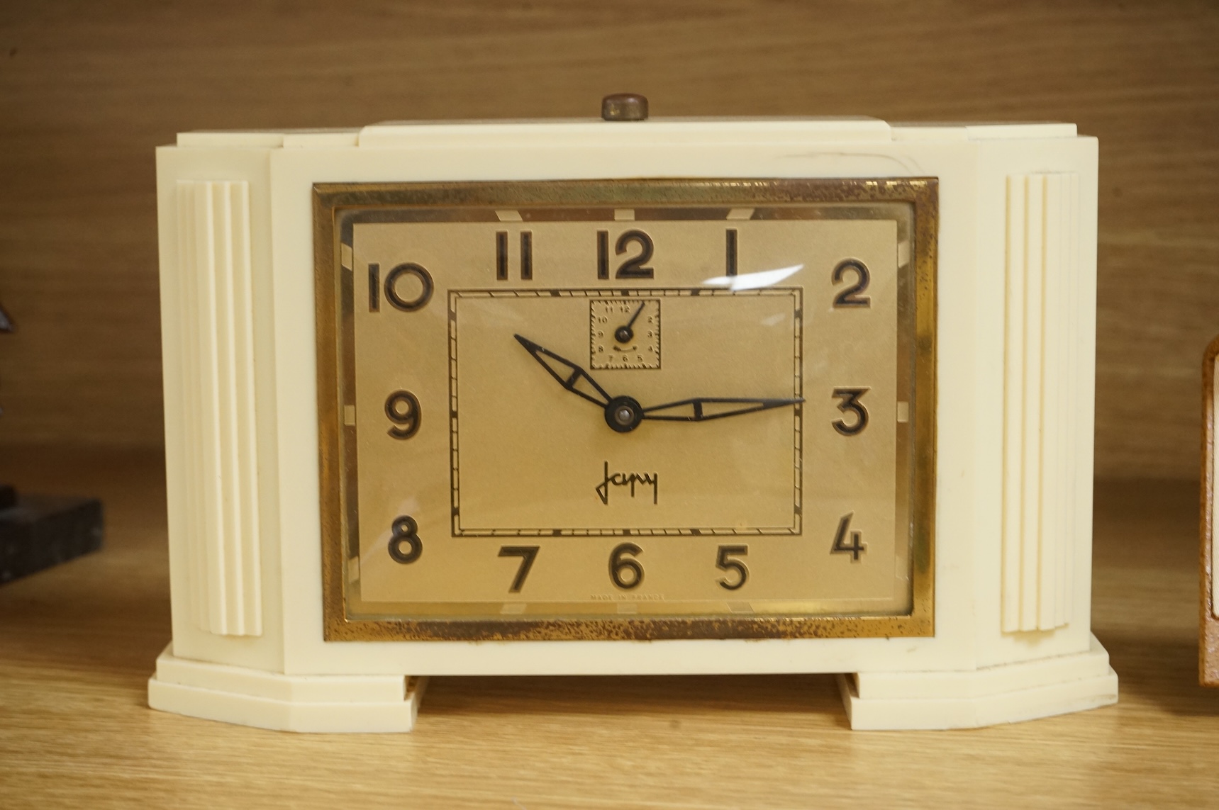 Two Art Deco timepieces comprising a Japy alarm clock and a Jas cased travelling example, largest 22cm wide